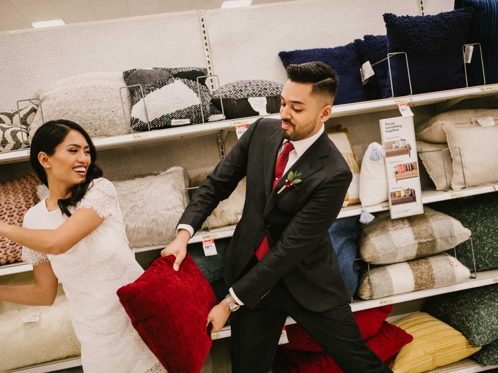 Bride and groom have pillow fight in Target pillow aisle