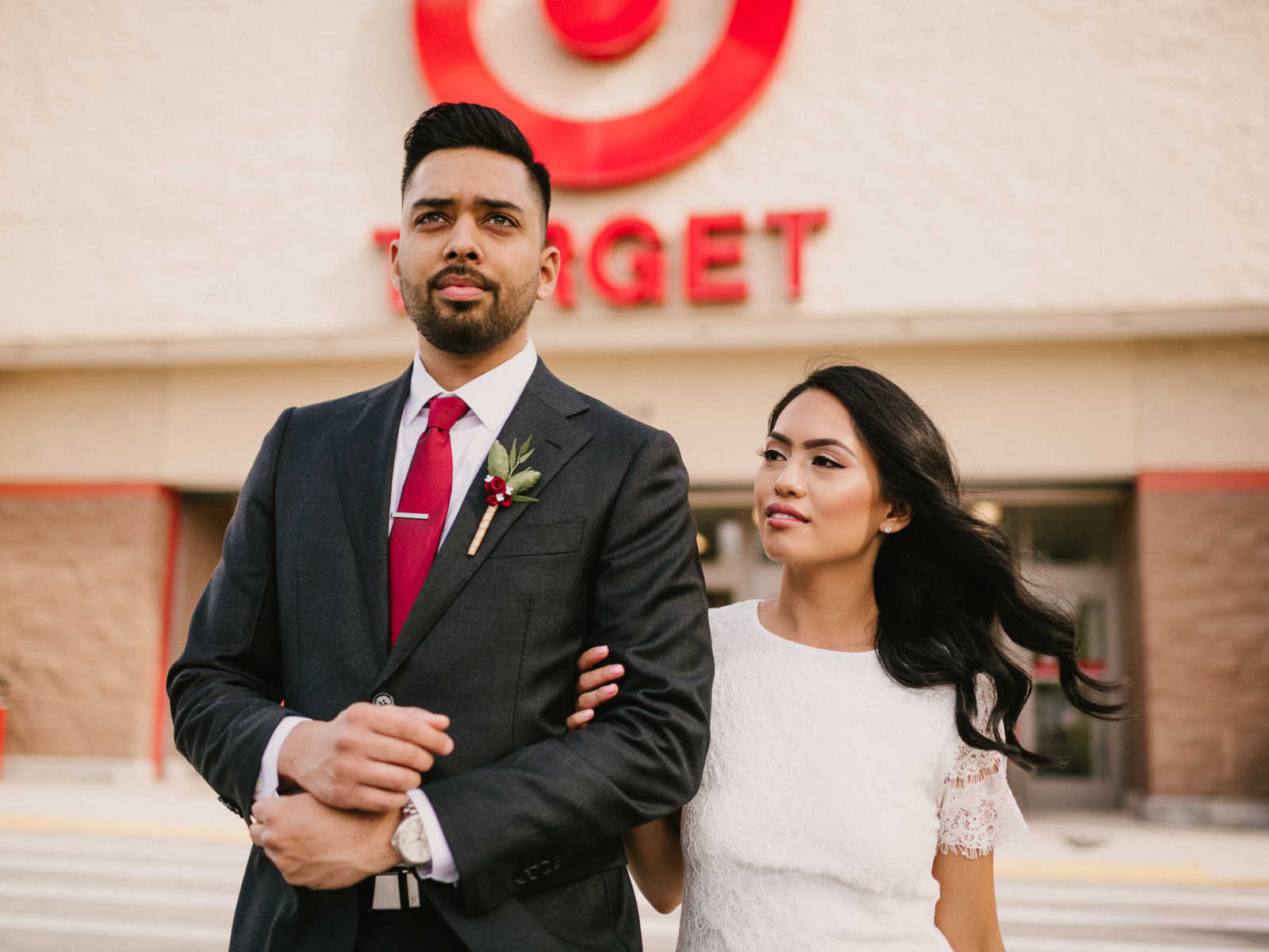 Bride and groom stand posing outside of Target in parking lot