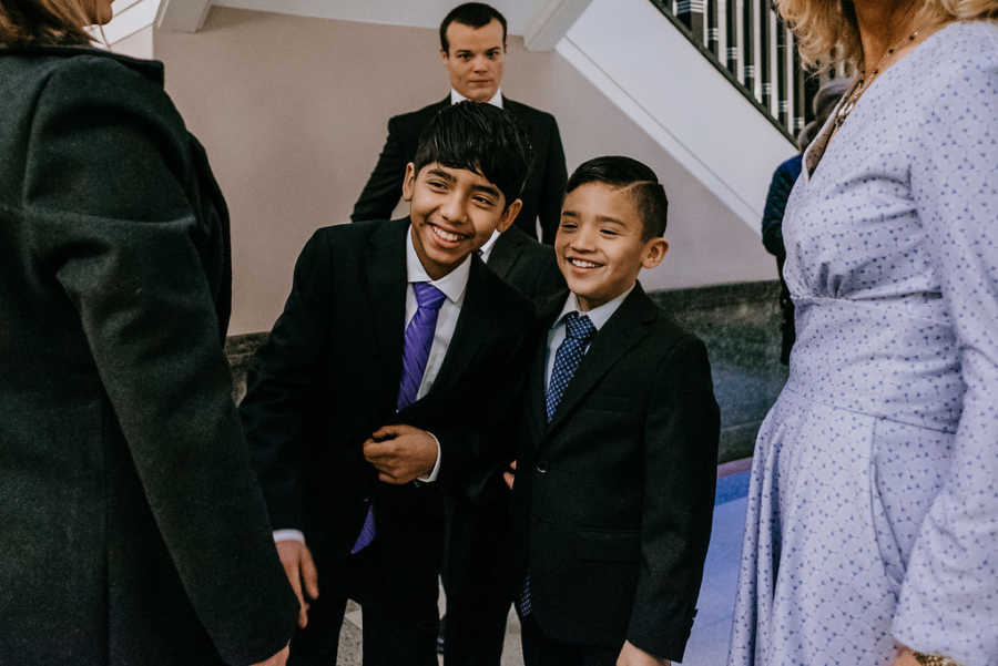 Two boys up for adoption smiling in suits at court