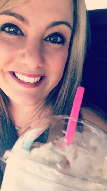 Woman smiling in selfie with coffee drink and pink straw to symbolize act of kindness
