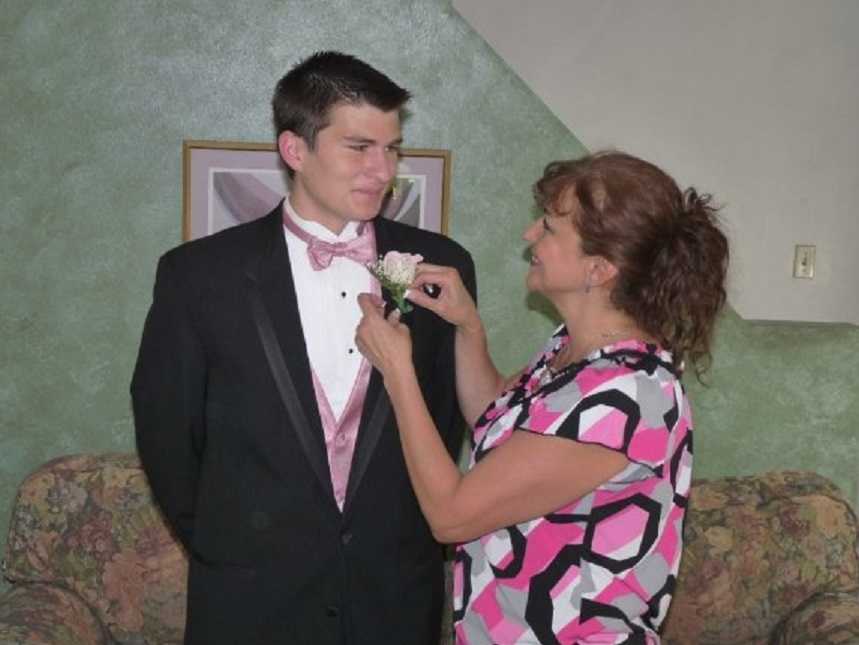 Mother who was in coma places boutonniere on son for school dance