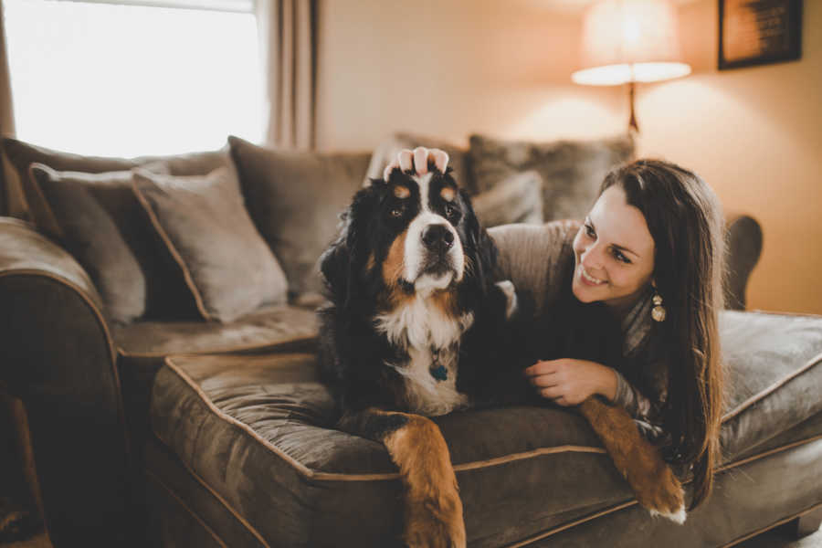 Woman smiles next to Bernese mountain dog who died 10 days before her brother