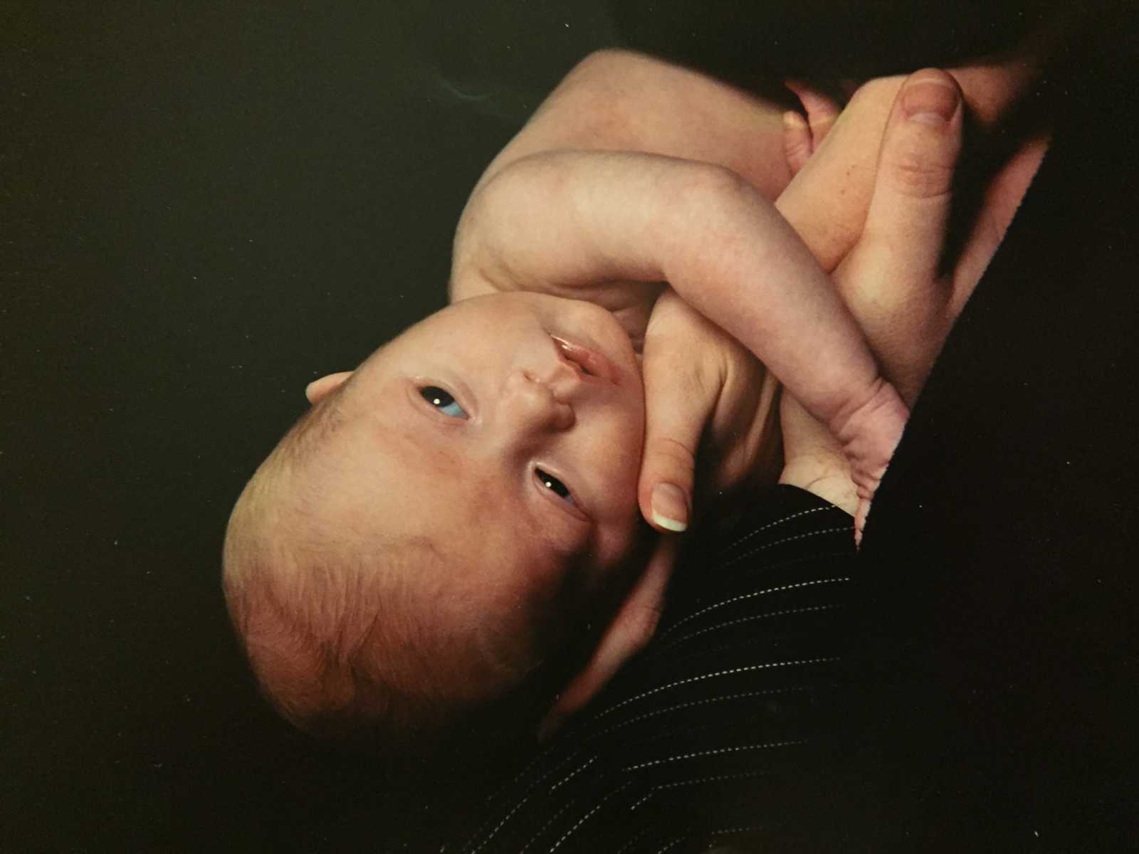 Close up of toddler lying on mothers chest