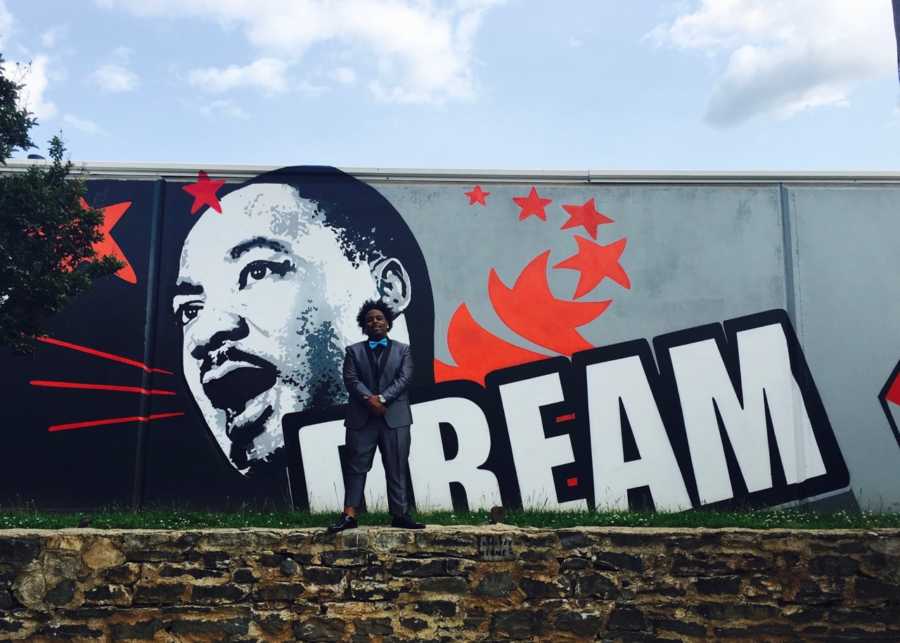 Teen stands in front of MLK graffiti wall dressed for girlfriend's prom