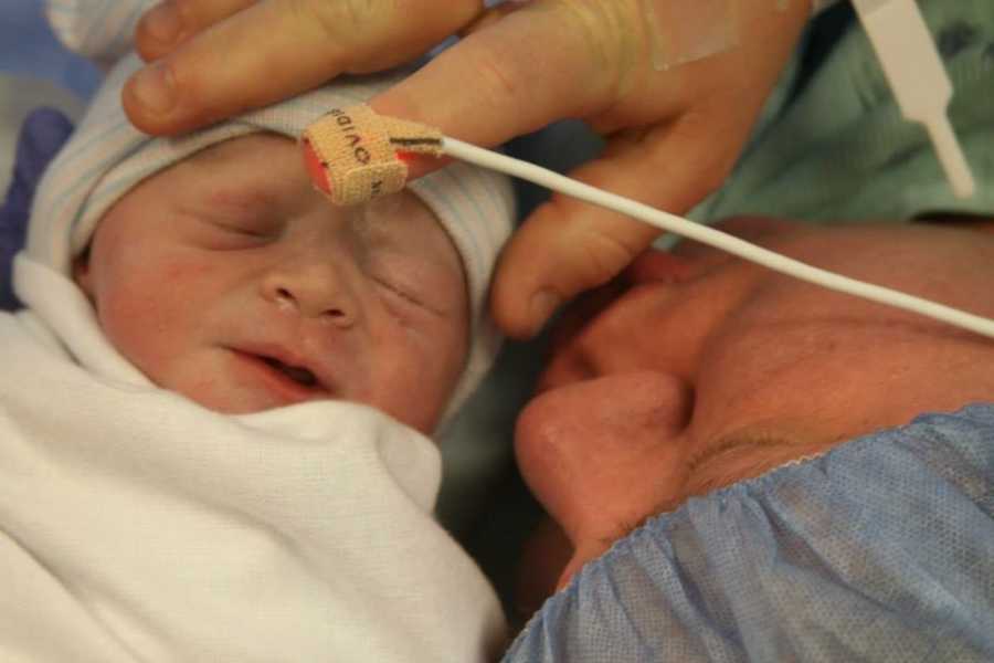 Close up of mother holding newborn's head