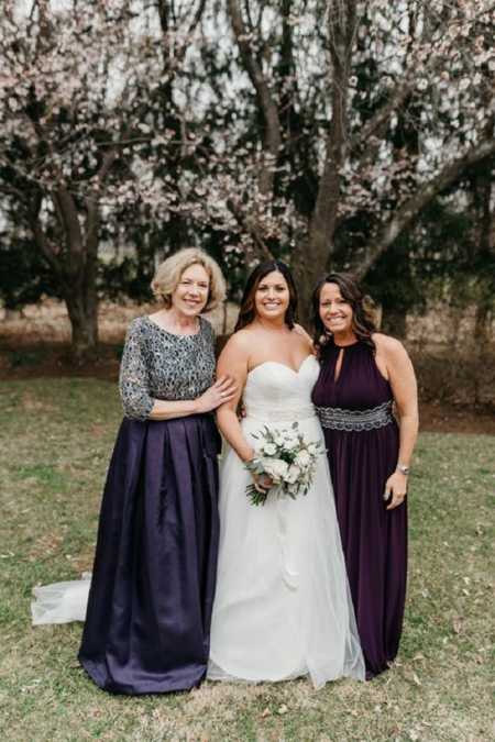 Woman on her wedding day standing with adopted mother and birth mother