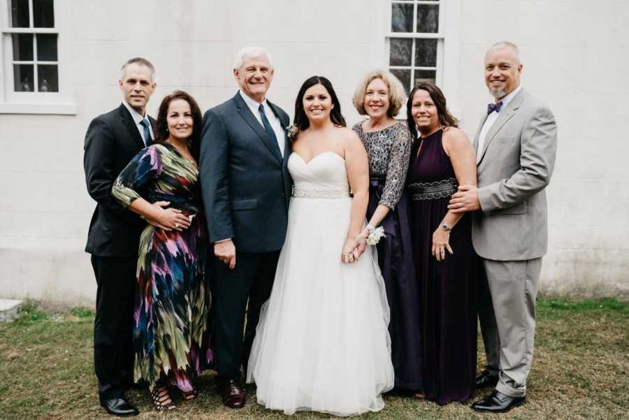  Bride on her wedding day stands with birth parents, adopted parents, and other couple 