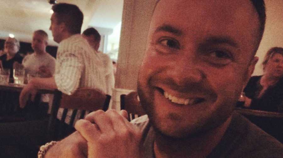 Man who says,"raise good men and women" smiling at restaurant table