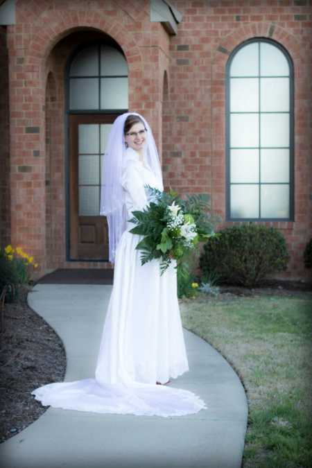 Bride standing in walkway wearing dress made by her grandmother
