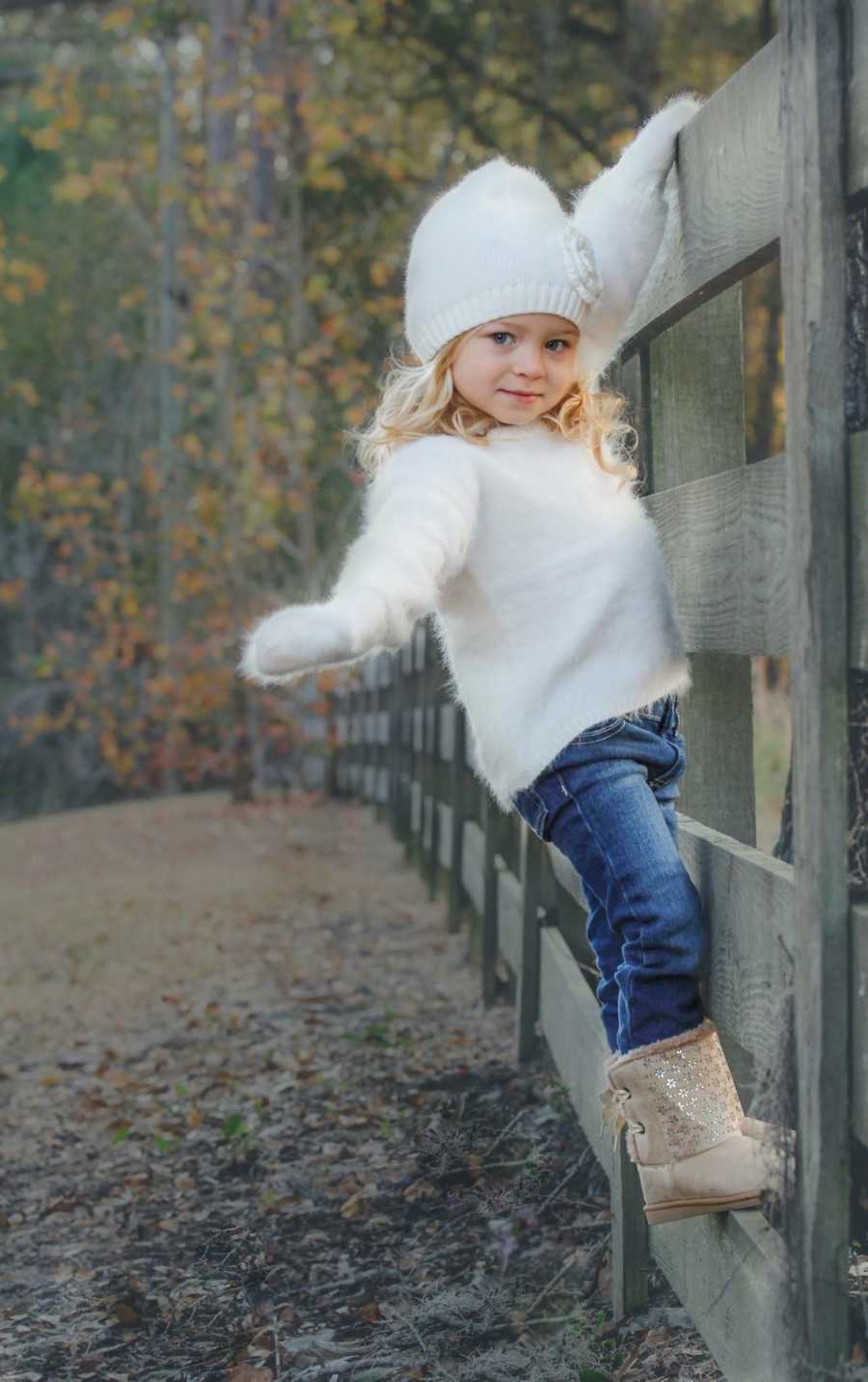 Birth child of parents who adopted 6 other children hanging on to wooden fence