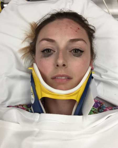 Woman who was in car accident lying in hospital bed with neck brace and eyeliner still in tact
