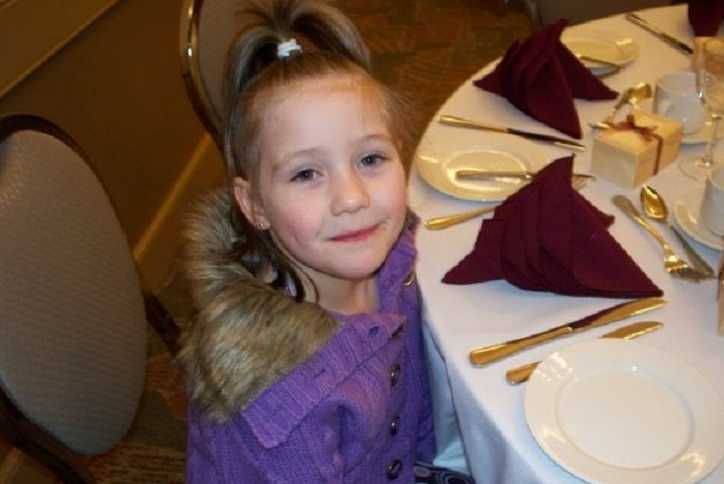 5 year old girl who is in foster care sitting at table setting