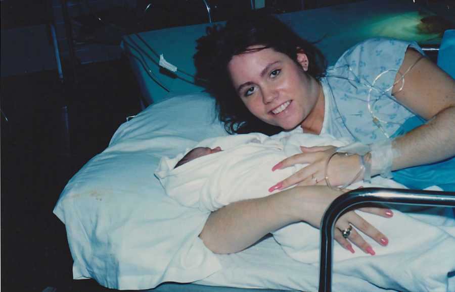 Birth mother laying in hospital bed with her newborn that she put up for adoption 