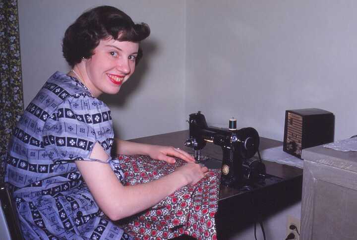 Woman whose clothes she made would be worn for generations smiling while sewing 