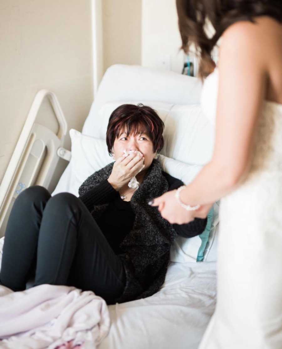 Mother who is terminally ill cries in hospital bed while looking at daughter in wedding dress