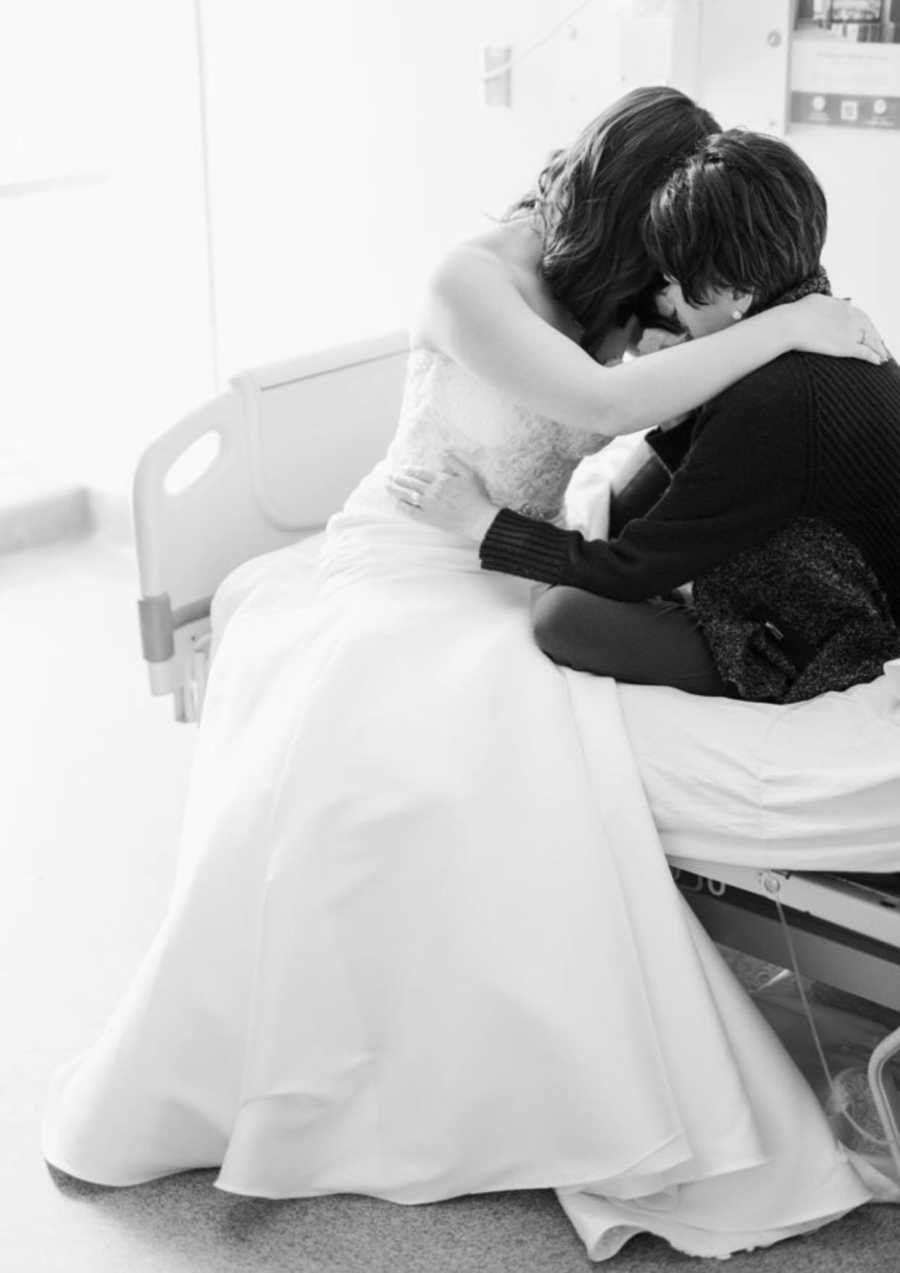 Terminally ill mother sits in hospital bed hugging daughter in wedding gown 