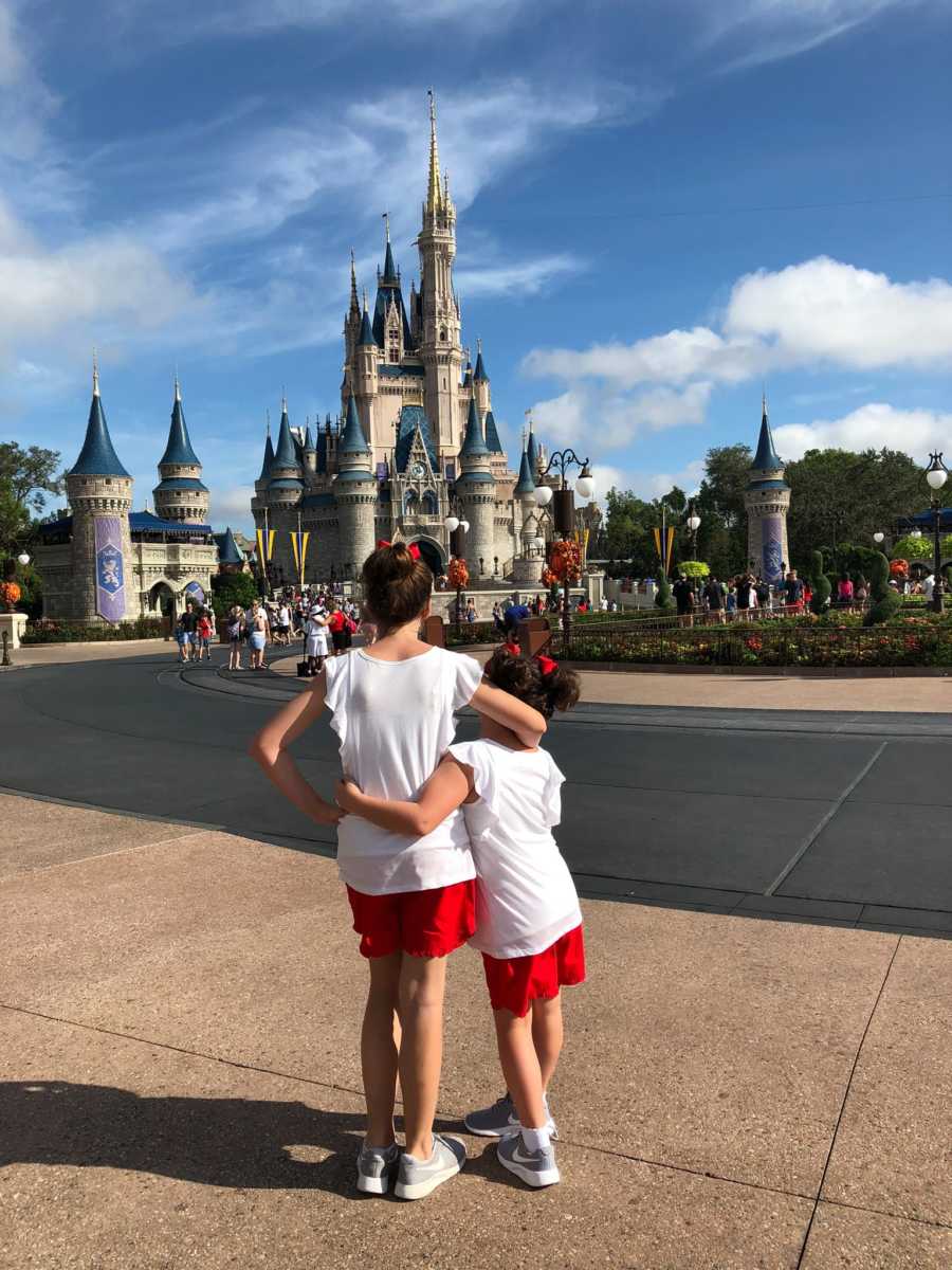 Nine year old who said she'd never feel joy stands with arm around younger sibling at Disney World