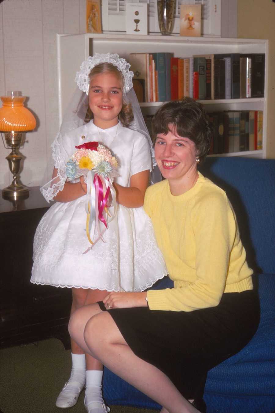 Mother sitting next to daughter whose wearing white dress mother sewed for her