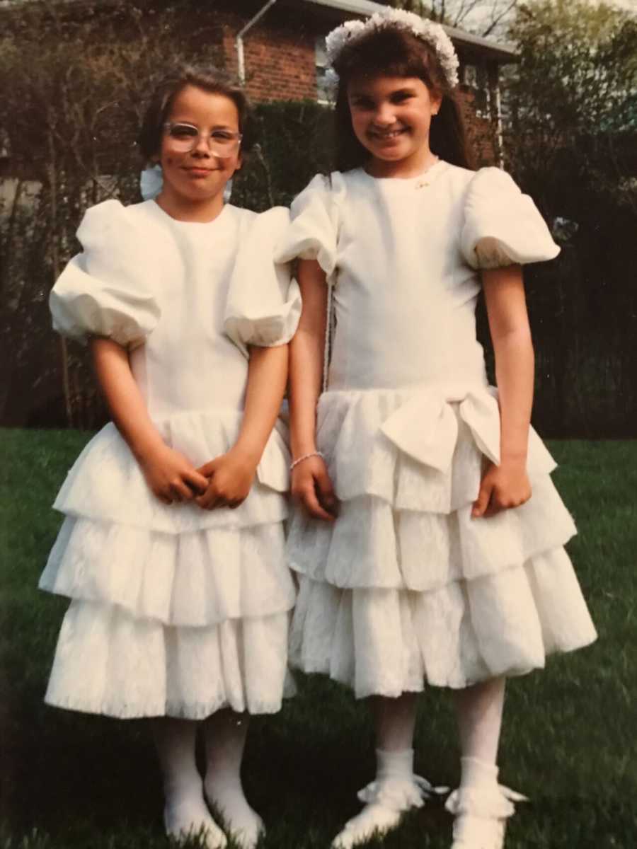 Two young girls standing in white dresses that their mother sewed for them