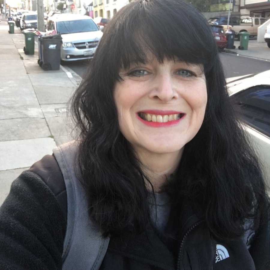 Recovered heroin addict mother smiles in selfie while walking down street