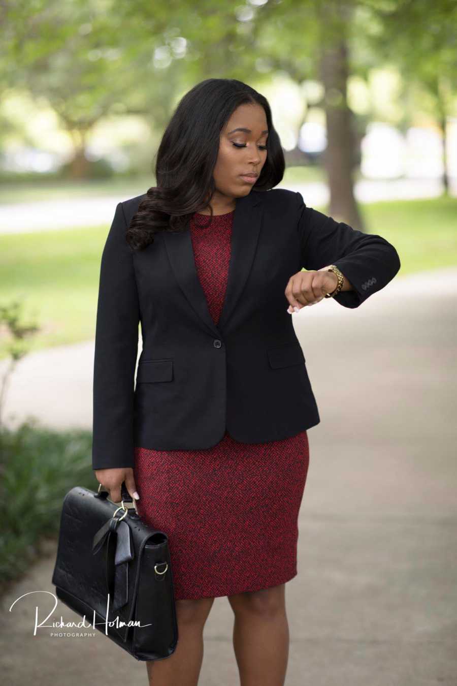 Single mother of five holding a brief case and looking at her watch