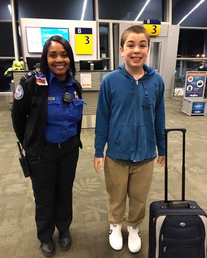 Teen with autism smiles next to TSA agent in airport