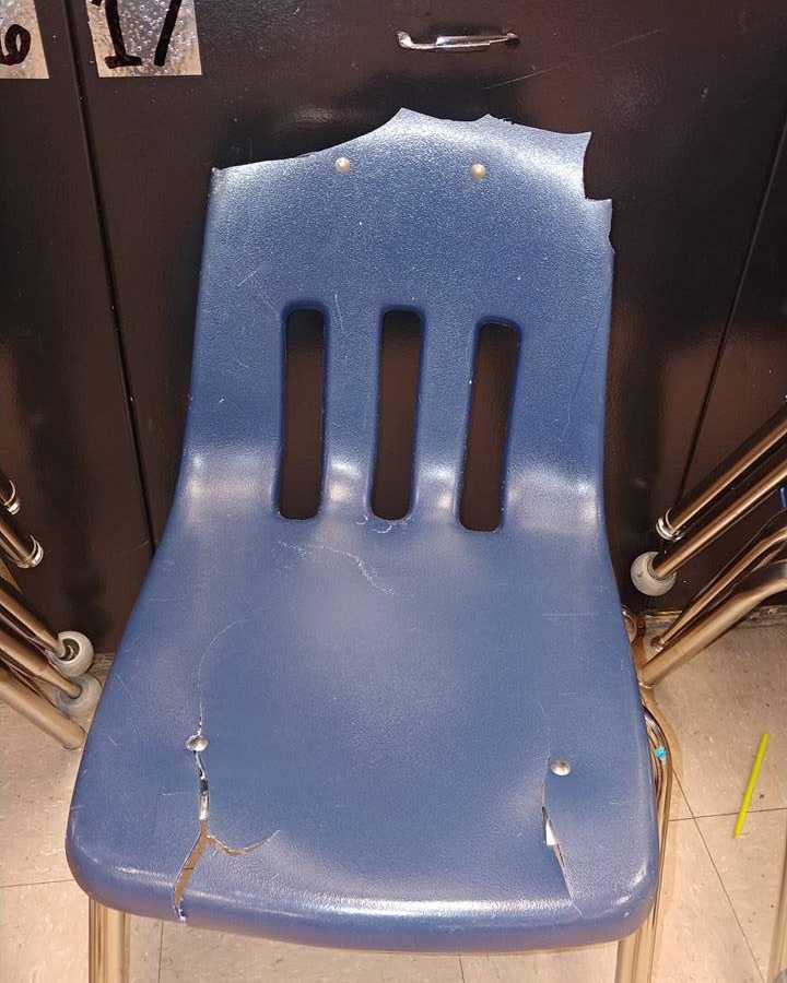 Blue plastic classroom chair that is broken
