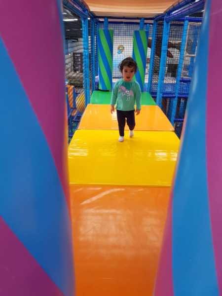 Little girl walking on rainbow play structure