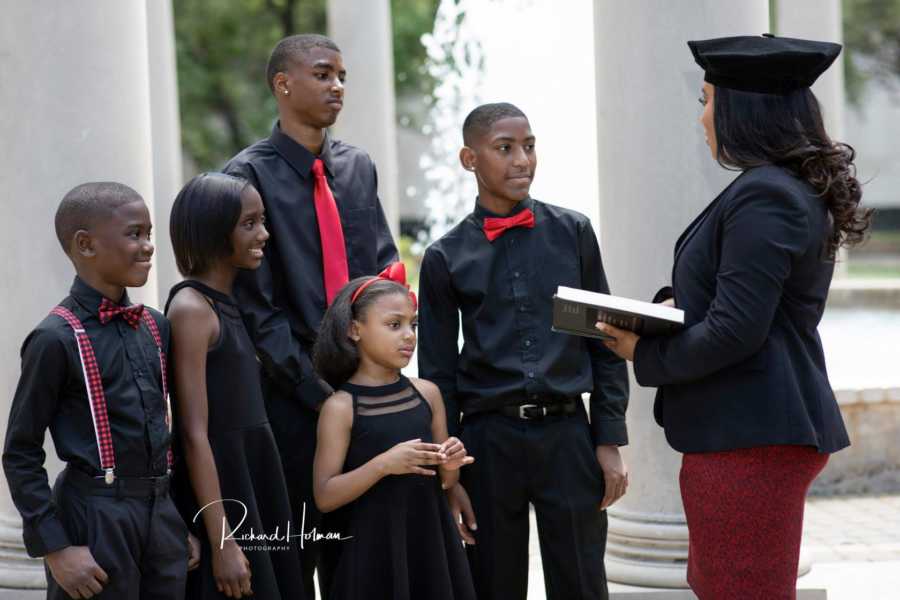 Single mother of five who just graduated law school stands in front of children reading law book