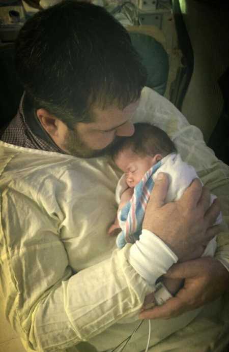 Father holds newborn daughter who will have to use a wheelchair her whole life to his chest 
