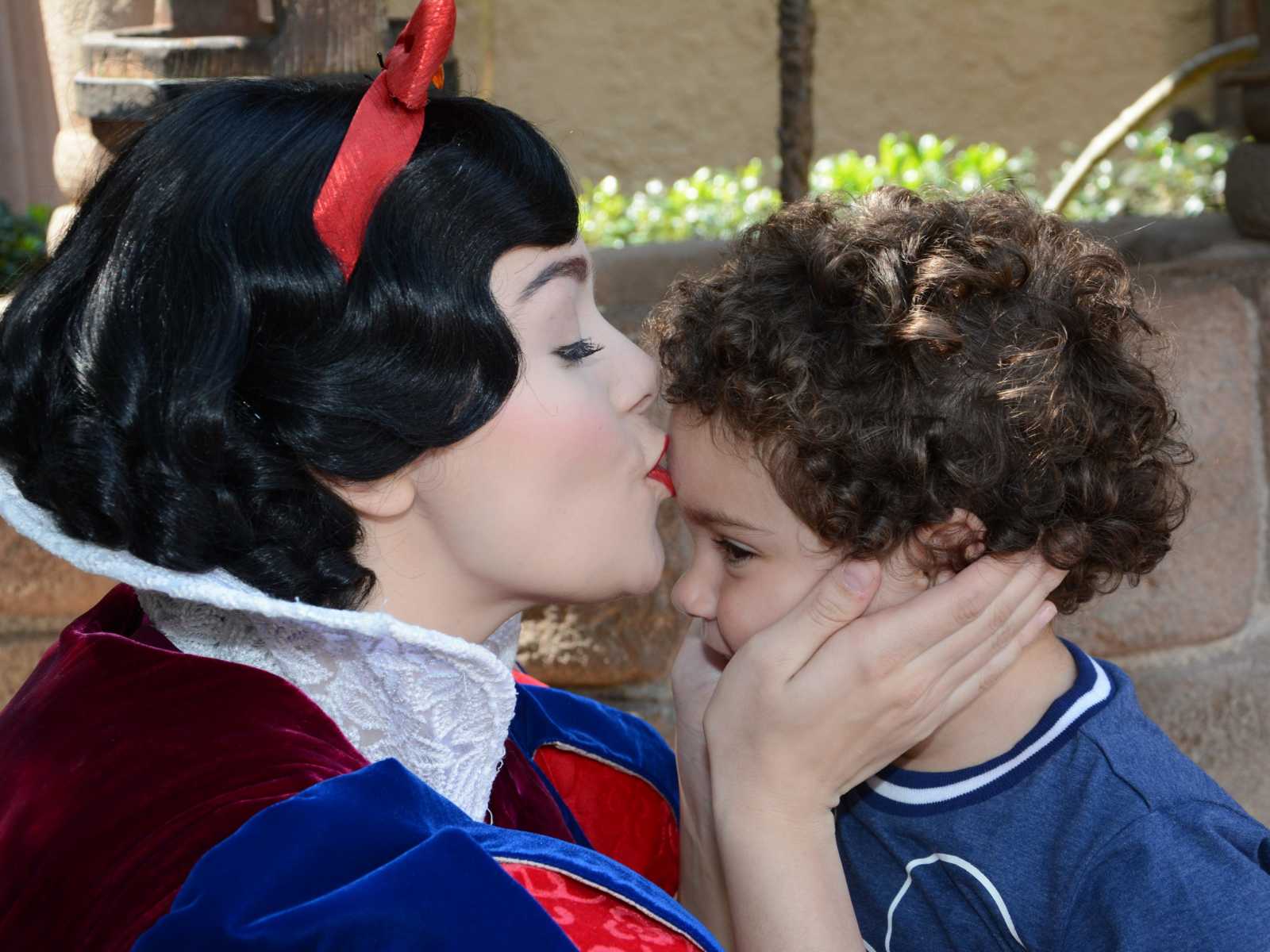 Snow White kisses forehead of toddler at Disney World