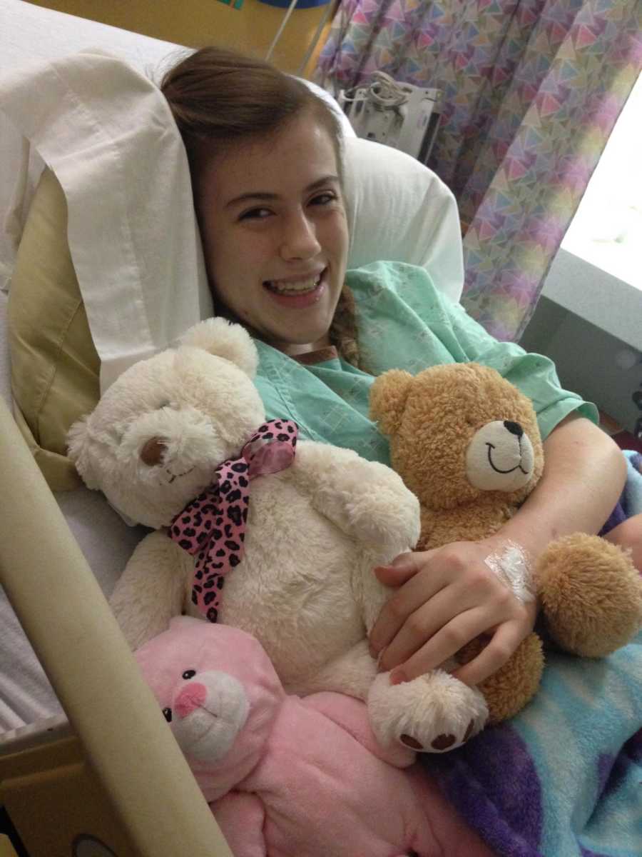 Teen girl with special needs lying in hospital bed with stuffed bears after spinal surgery
