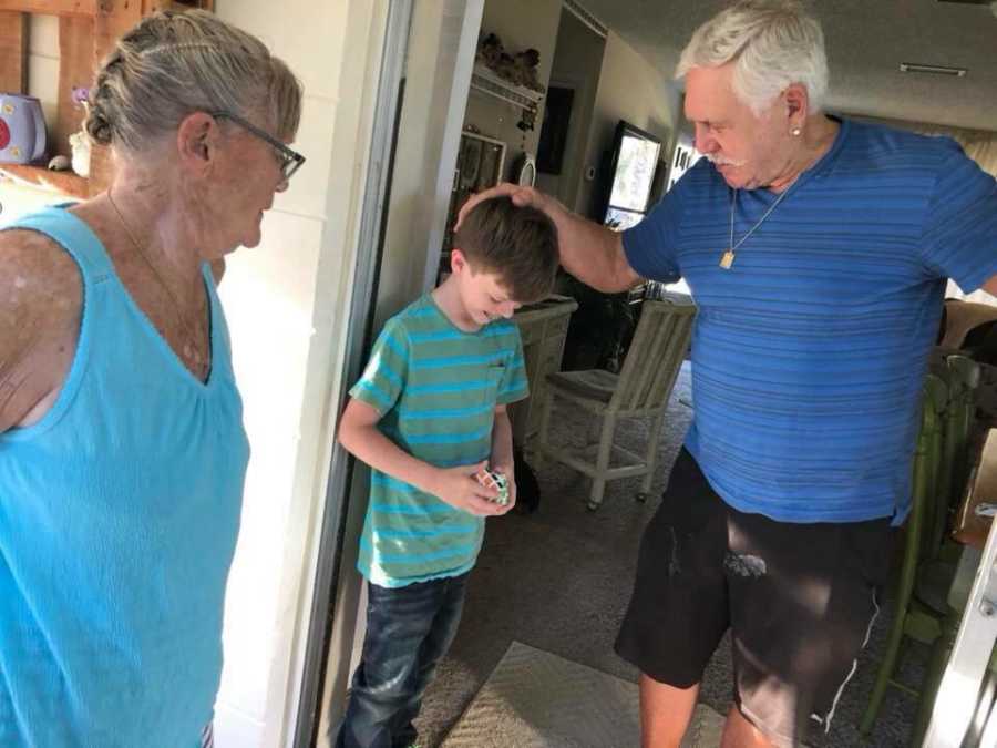 Grandfather who helped raise his granddaughter holds great grandsons's head beside wife