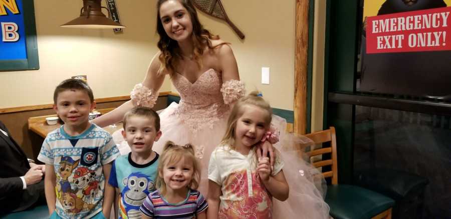 Four young kids stand in front of teen in prom dress at diner who they thought was a princess