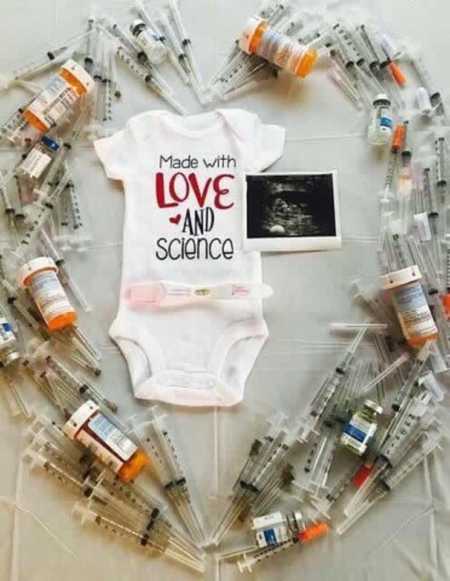 Onesie saying, "made with love and science" at center of IVF needles in shape of heart