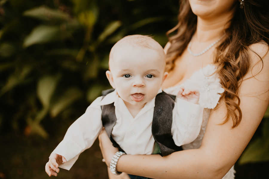 Bride holds baby son in suit who demanded breast milk at wedding