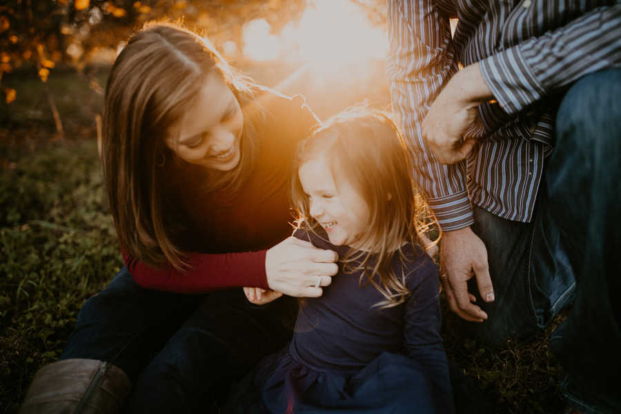 Toddler giggles as her mother with breast cancer tickles her