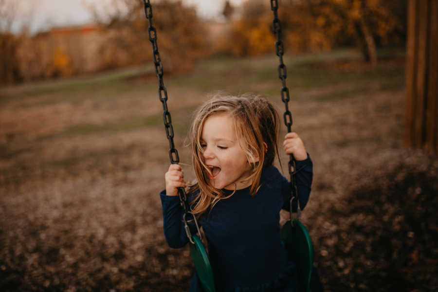 Toddler whose mother has terminal breast cancer smiles while on swing set