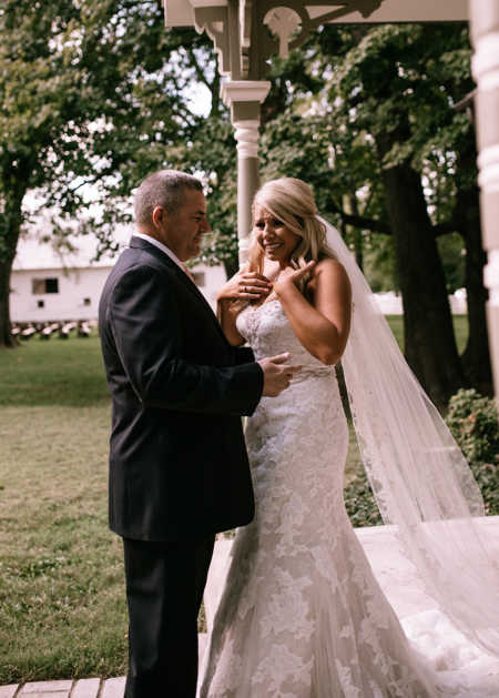 Bride smiles while crying beside her father