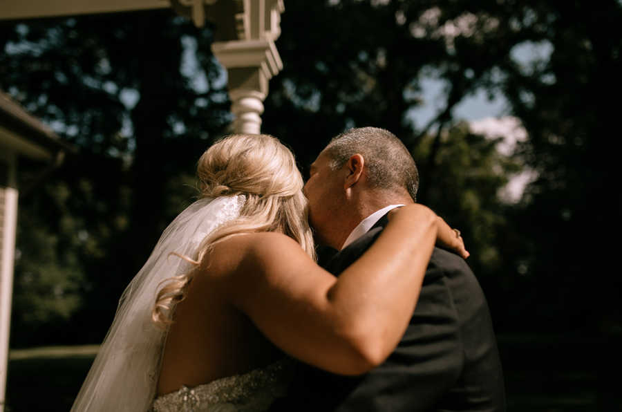 Father kisses cheek of his daughter who is getting married