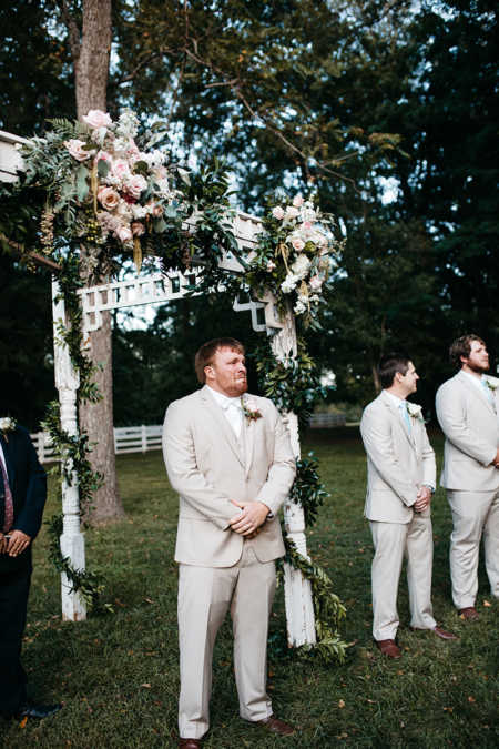 Groom cries at altar of outdoor wedding