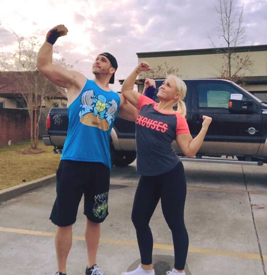 Couple who found each other through fitness journey standing in parking lot flexing their muscles