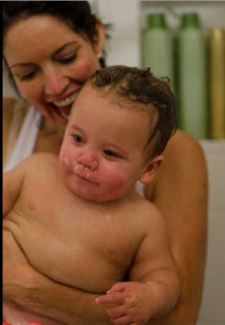 Woman smiles while holding adopted baby son