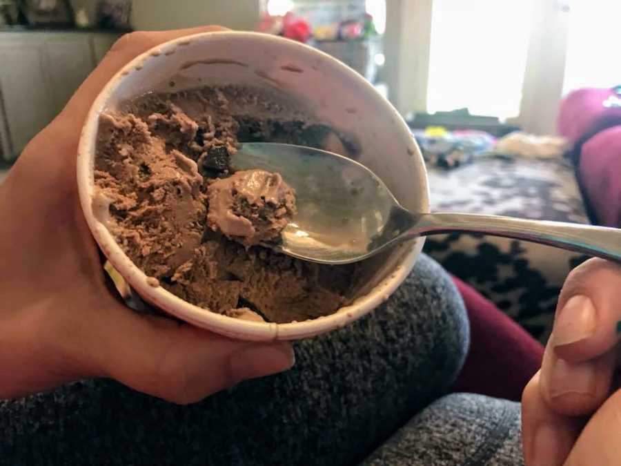 View of mother scooping a spoonful of ice cream from her son's ice cream
