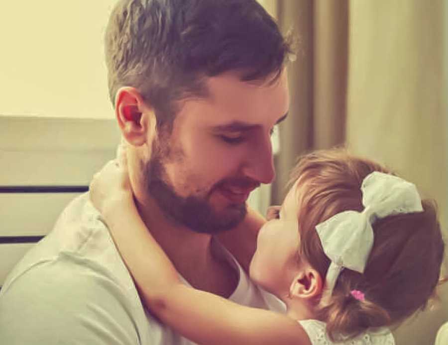 Military father who is away a lot smiling down at toddler daughter