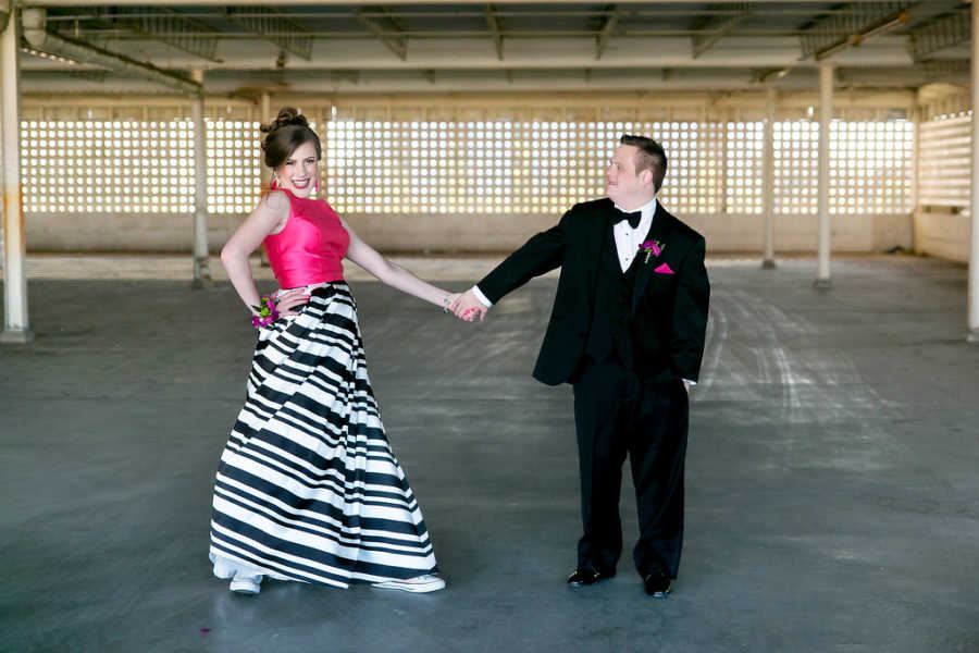 Special needs prom dates hold hands and smile