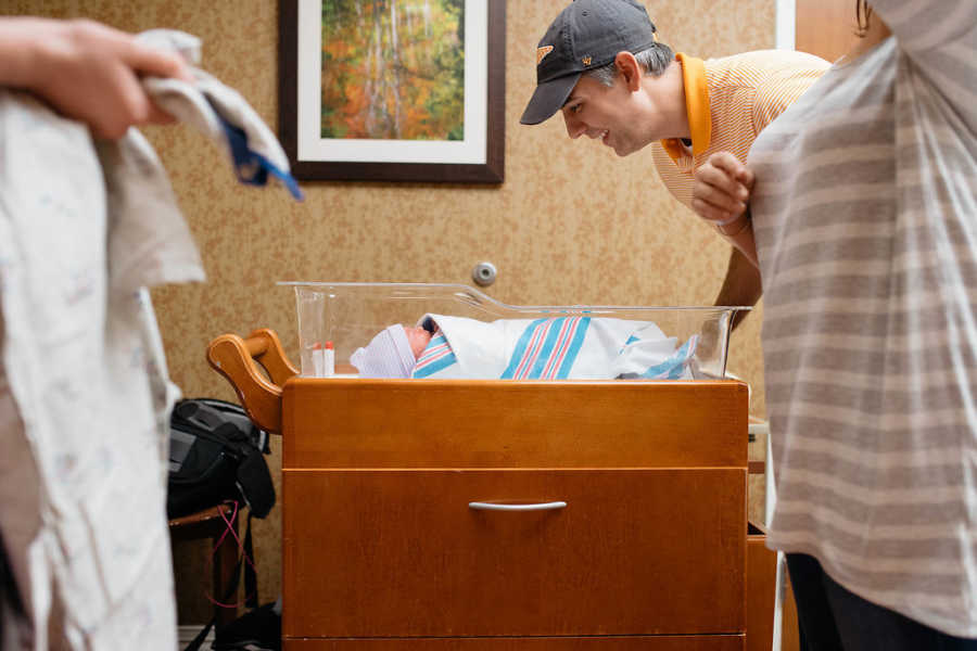 Man stands over newborn adopted child asleep in hospital 