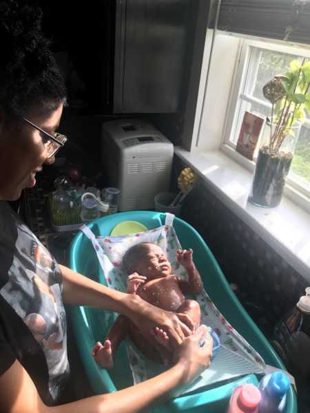 Mother who gave birth in different country in hotel room gives him bath in sink