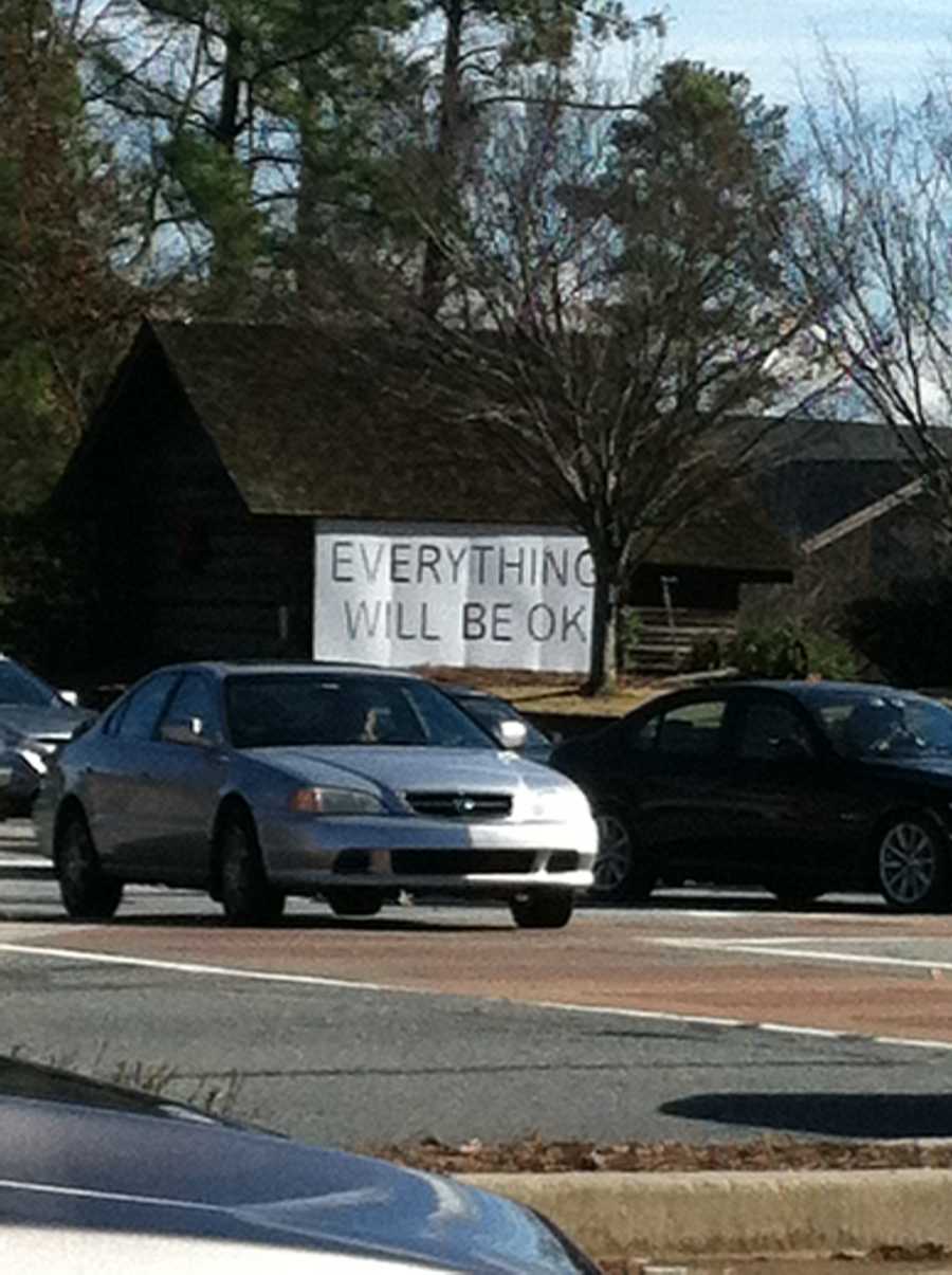 Large sign on house saying, "everything will be ok" seen by woman whose husband has cancer