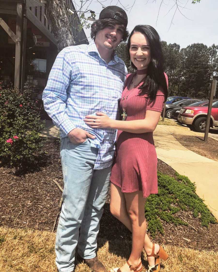 Girlfriend smiling with arms wrapped around boyfriend who bought her a house before ring